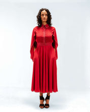 Woman wearing a red dress with a cape on a white background from Leh Studios.